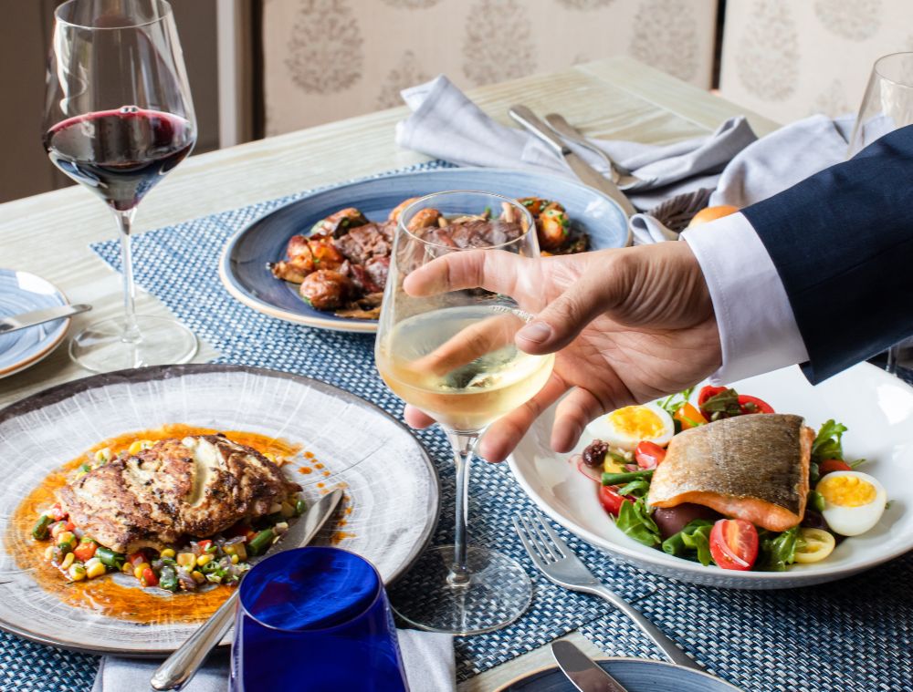 Person holding drink with food on a table