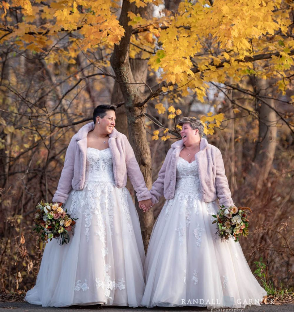 Brides holding hands outside the Inn at Hastings Park