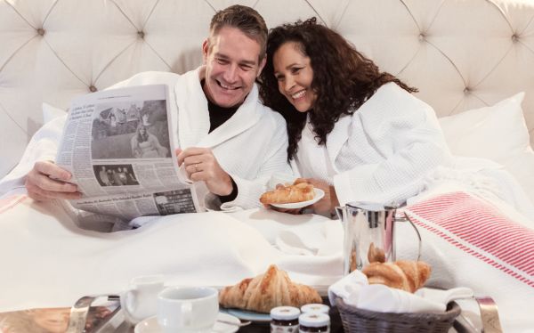 Couple laying in bed at the Inn at Hastings Park