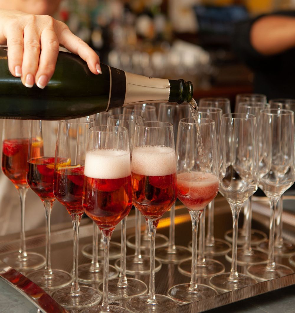 Person pouring wine in glasses