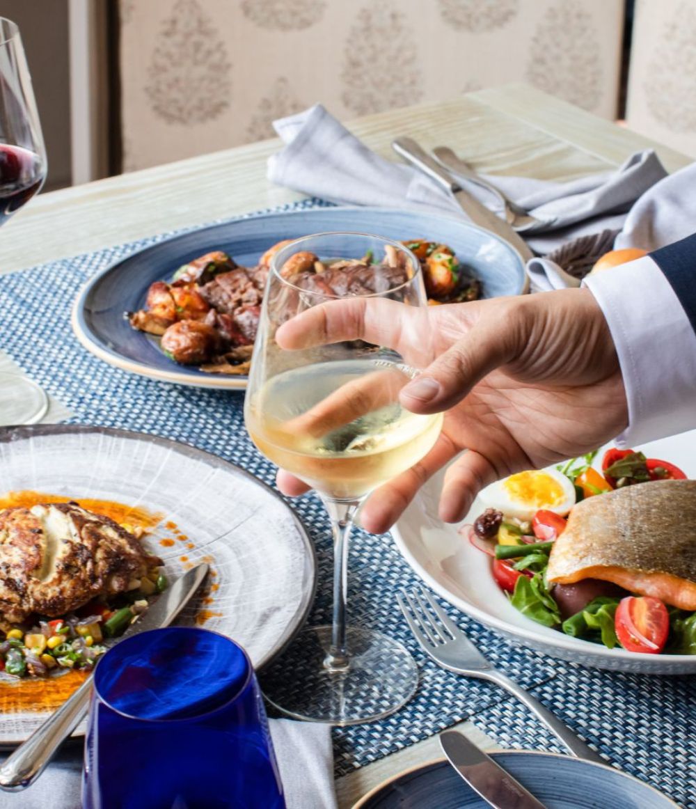 Person holding glass with food on plates