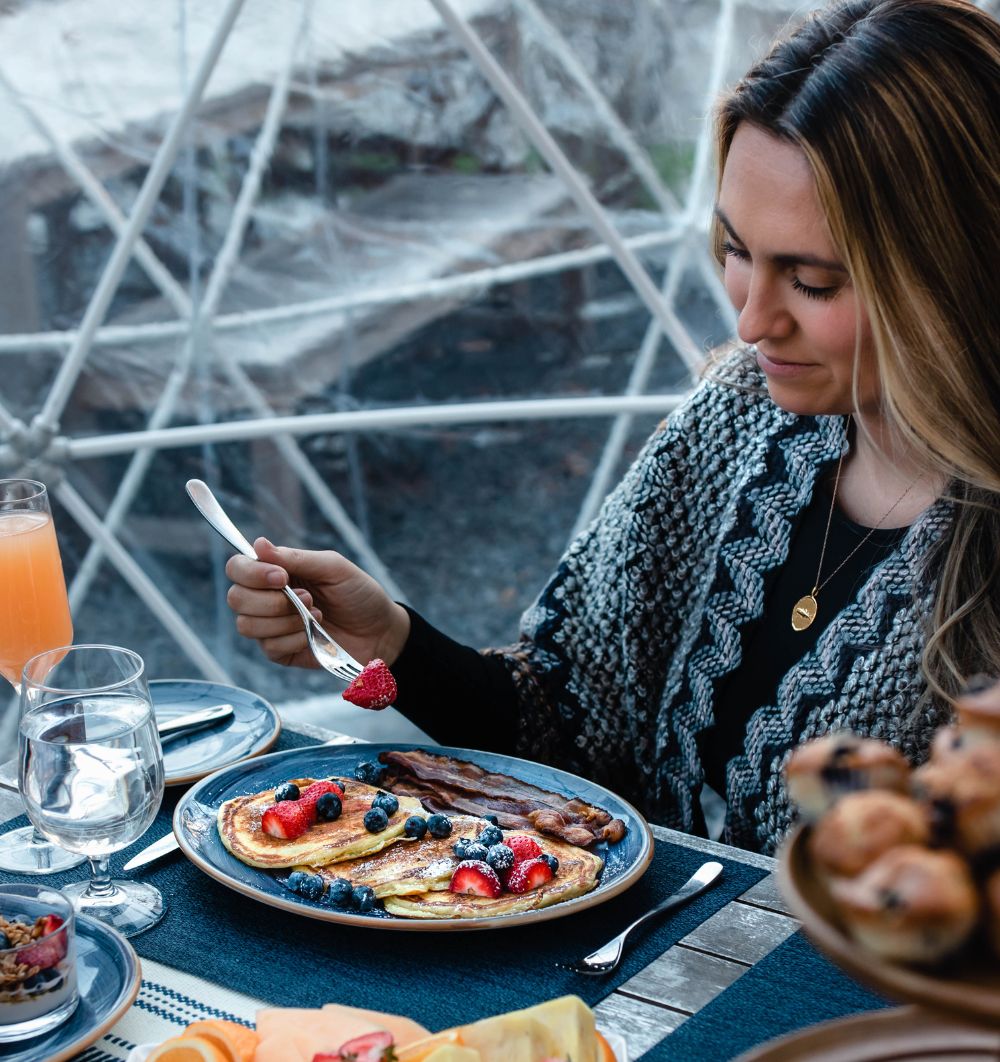 Woman eating food on a plate in an igloo