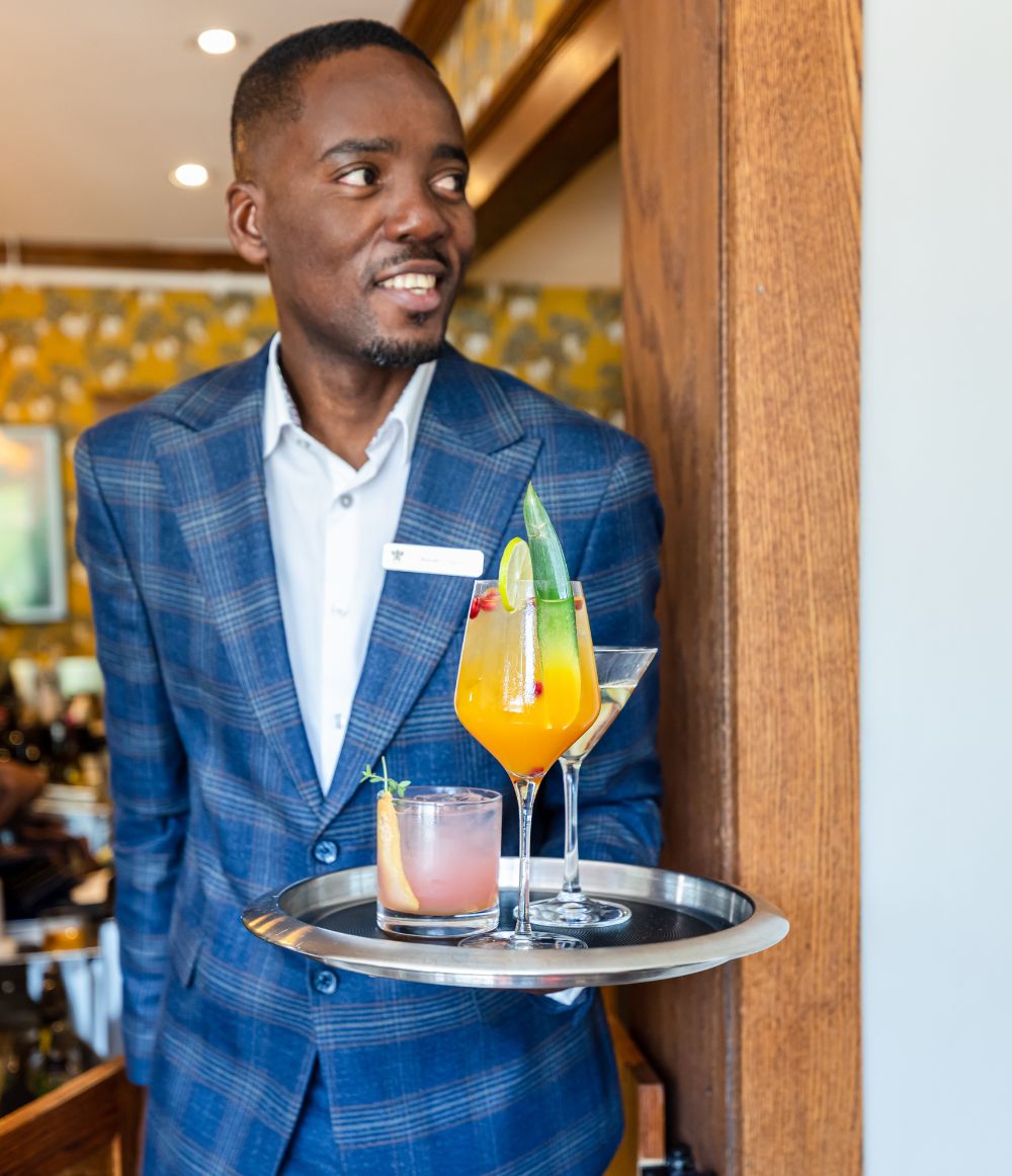Man holding cocktail drinks on a tray